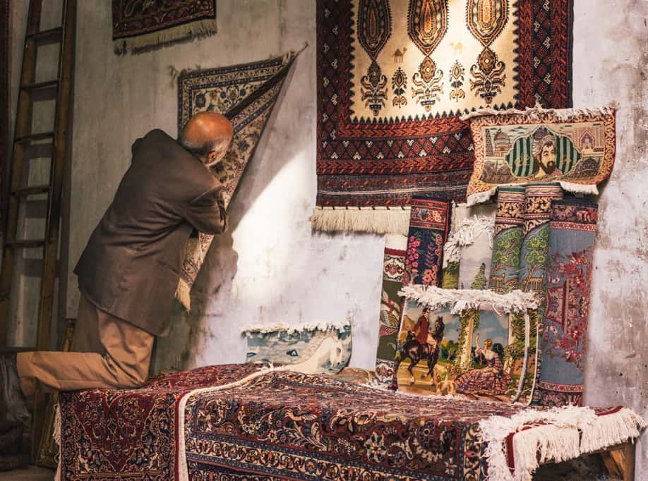 Man Going Through His Carpets At The Market